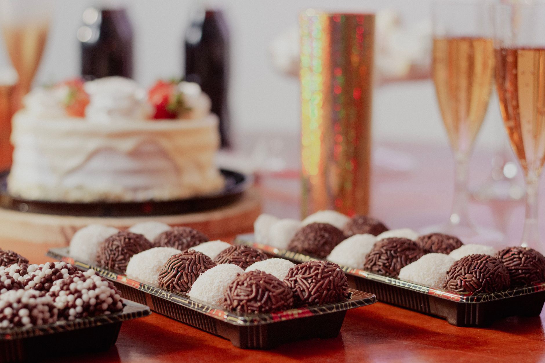 A sophisticated party setup featuring a cake, truffles, and champagne flutes, perfect for a cheerful celebration.