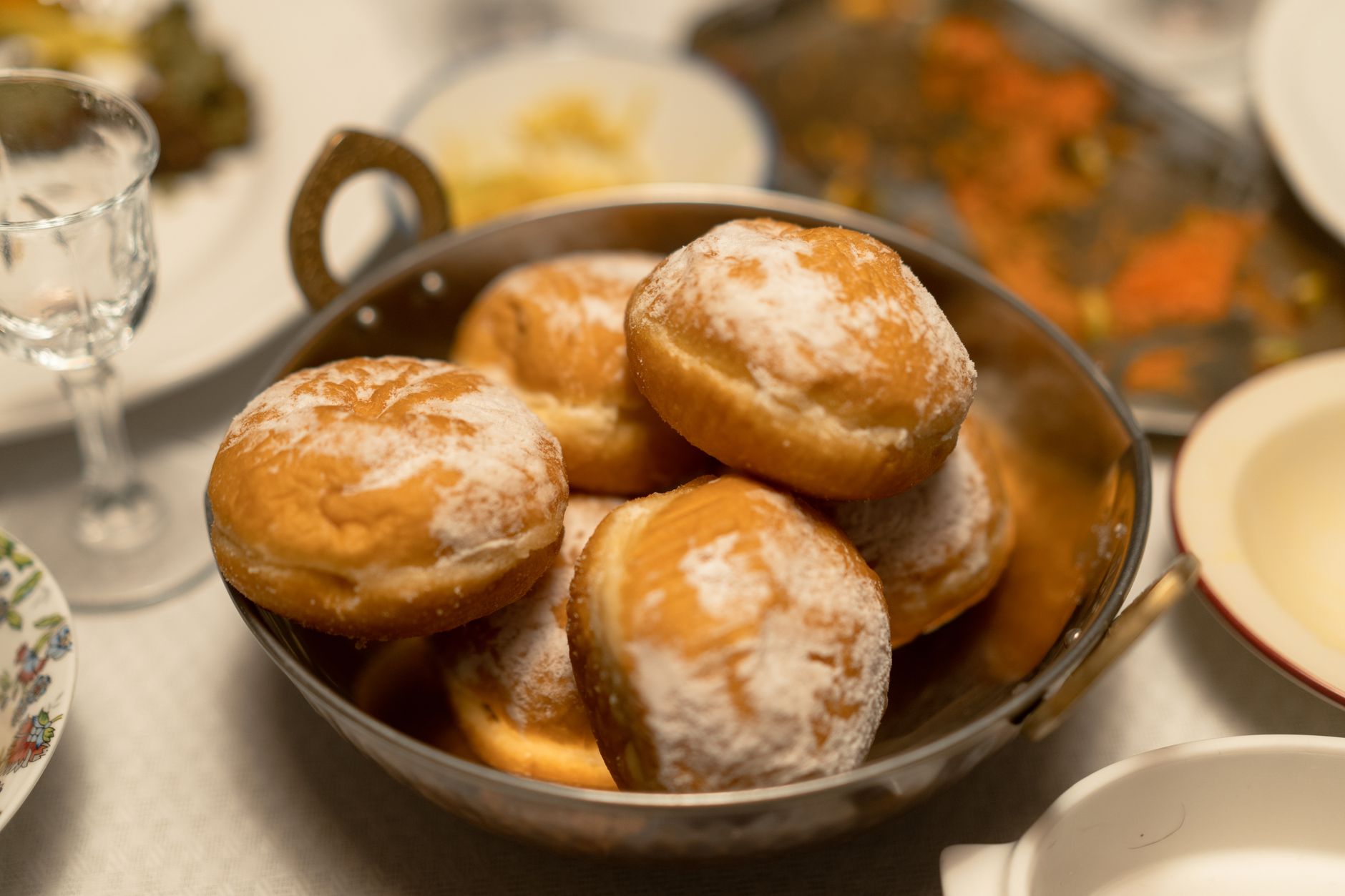 A close-up of sugared sufganiyot in a bowl, perfect for Hanukkah festivities.